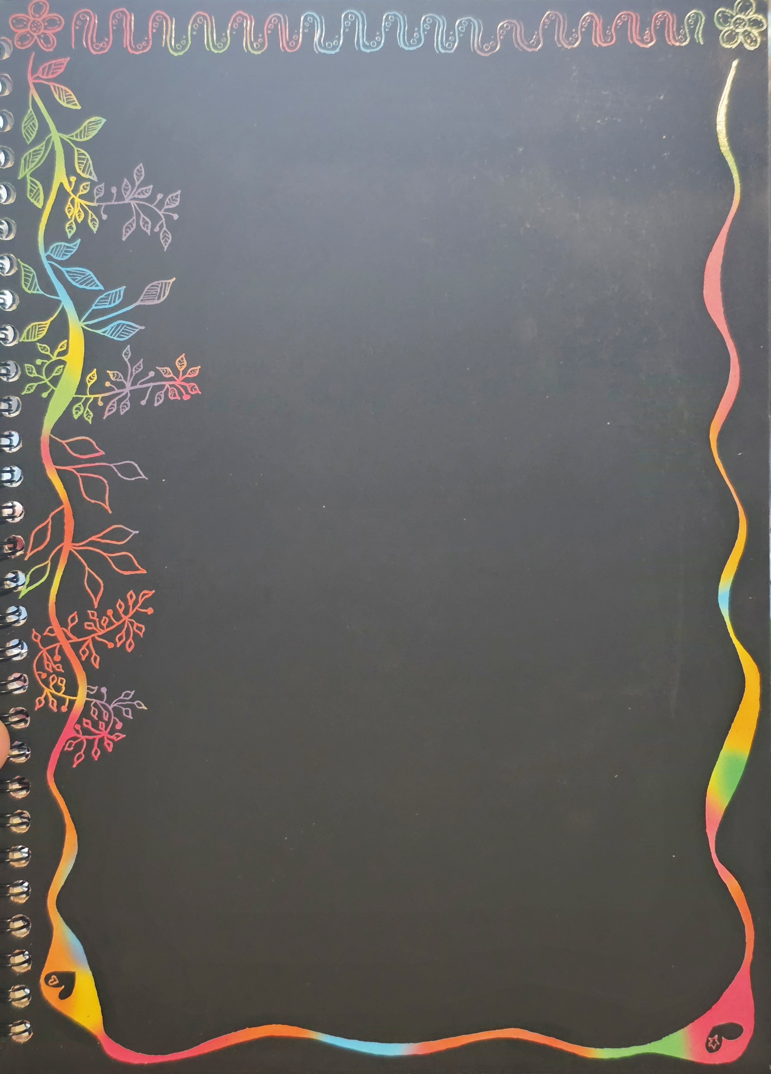 A scratch art work in progress showing flowers & vines with leaves.