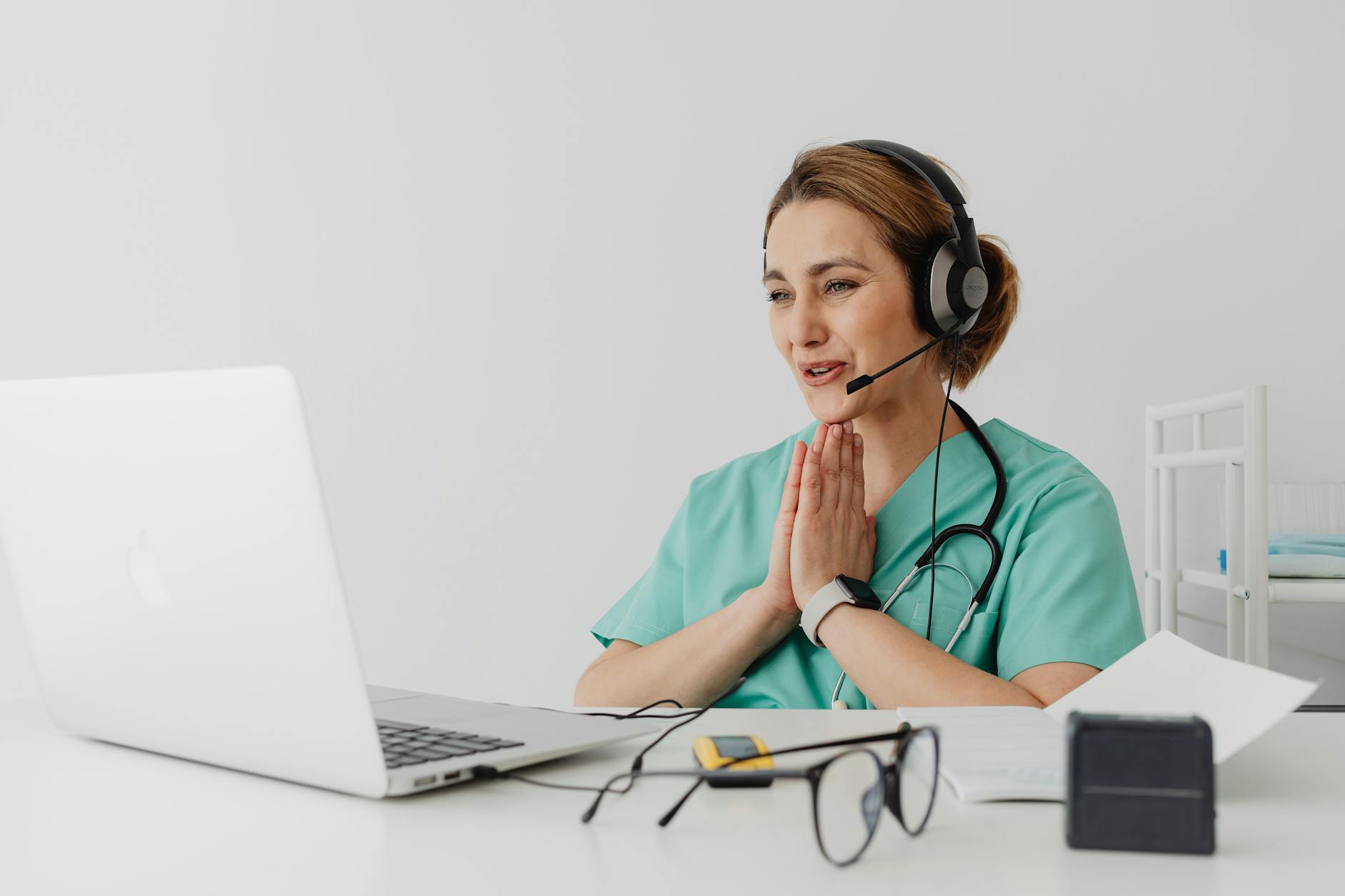 Nurse in front of a laptop, taking a patient call.
